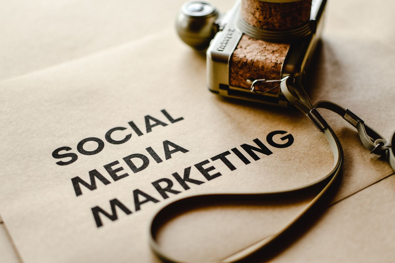 about-01 Close-up of a camera placed on brown paper with Social Media Marketing text, emphasizing digital marketing themes.